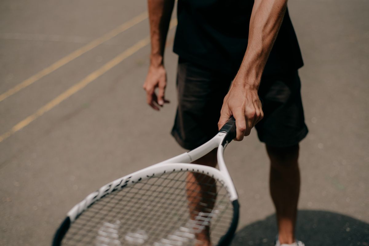 Player holding a tennis racket on an outdoor court